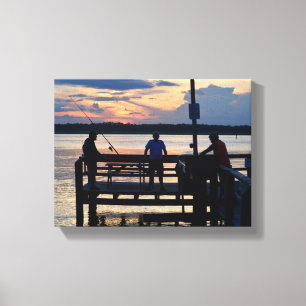 People on a pier fishing at sunset canvas print