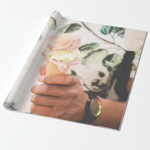 Person holding ice cream cone with three flavours wrapping paper