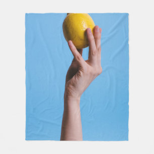 Person holding lemon fleece blanket