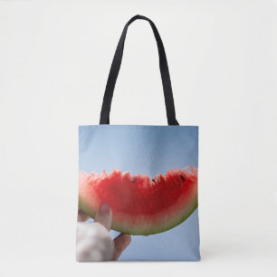 Person holding sliced watermelon tote bag