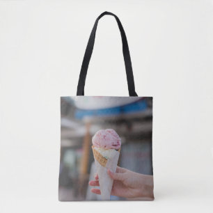 Person holding strawberry ice cream tote bag