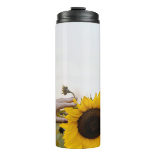 Person holding sunflower thermal tumbler
