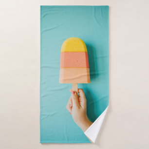Person holding yellow and brown ice cream cone bath towel