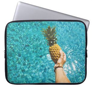 Person holding yellow pineapple laptop sleeve
