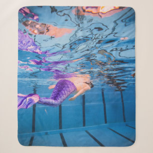 Person in purple pants lying on blue hammock sherpa blanket