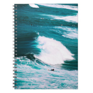 Person on surfboard with ocean waves notebook