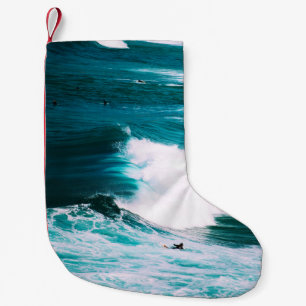 Person on surfboard with ocean waves small christmas stocking