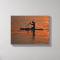Person silhoutte kayaking at river