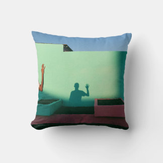 Person waving reflecting shadow on teal wall paint cushion