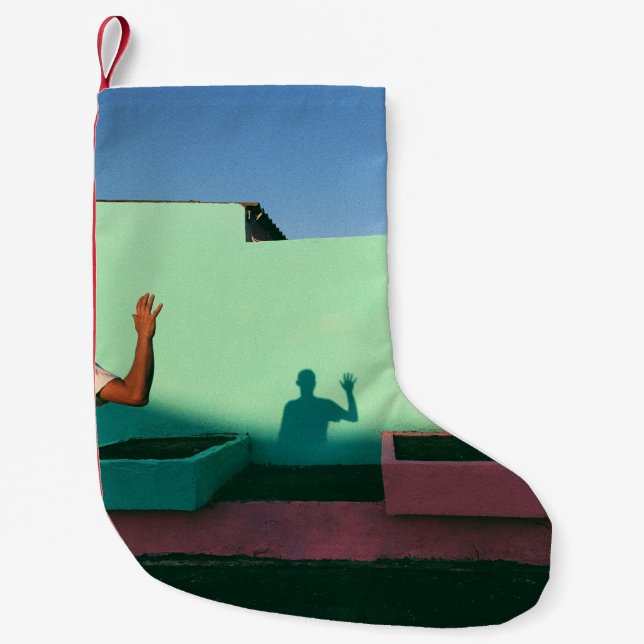Person waving reflecting shadow on teal wall paint small christmas stocking (Front)