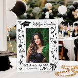 Personalised Doodle Graduation Photo Plaque<br><div class="desc">A fun graduation plaque featuring a senior photo framed by playful hand-drawn doodles including a graduation cap, diploma, stars, hearts, and confetti on a bold black background. The graduate's name appears in script at the top with the school name and class year below. A charming tabletop keepsake that doubles as...</div>
