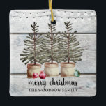 Personalised Rustic Wood Christmas Trees Holiday   Ceramic Ornament<br><div class="desc">Rustic Christmas trees and string lights ornament on a wood background with your family name,  for your holiday season. Earthy rustic country homey style. Merry Christmas with family name.</div>