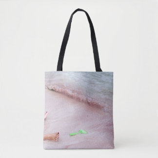 Person's foot beside green shovel on seashore tote bag