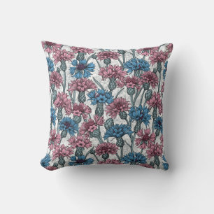 Pink and blue cornflowers, wild flowers on white cushion