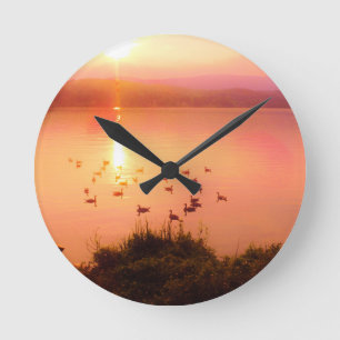 Pink and peach lake sunset round clock