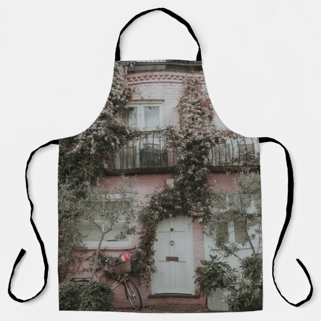 PINK AND WHITE PAINTED HOUSE COVERED WITH PLANTS A APRON (Front)