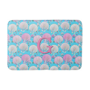 Pink and white sea shells on turquoise bath mat