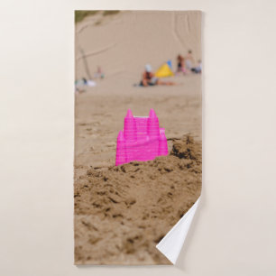 Pink castle toy in shore at daytime bath towel