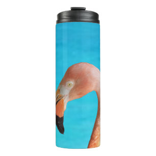 Pink flamingo face against blue water on a thermal tumbler