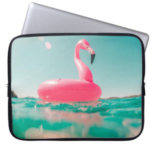 Pink flamingo swim ring on body of water in summer laptop sleeve