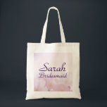 Pink Floral Bridesmaid Wedding Welcome Tote Bag<br><div class="desc">Greet your bridesmaids with a beautiful and practical personalised pink floral bridesmaid tote bag. The background is a soft watercolor pink floral. Her name and the title bridesmaid is below. Both name and bridesmaid are written in a pretty purple modern script font. Both words can be easily customised. Bridesmaid can...</div>