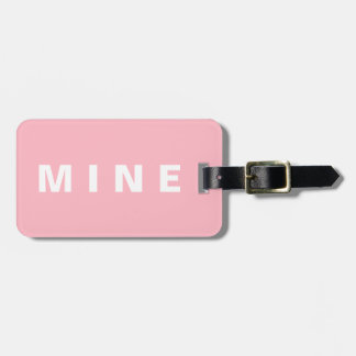 Pink luggage tag with 'Mine' written on it