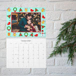Pixel Retro Gamers Christmas Photo Calendar<br><div class="desc">Celebrate the year ahead with a calendar that fuses Christmas cheer and gaming nostalgia. Personalise the front with your family name, year, and a festive photo, framed by pixel art holiday motifs. Each month showcases your treasured family photos, complemented by a vivid blue background featuring pixelated presents, bells, and snowmen....</div>