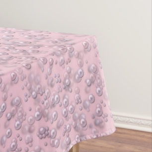 Placers of white-pink pearls on pink velvet tablecloth
