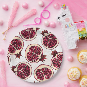 Pomegranate slices on white paper plate