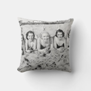Portrait of five young women lying on the beach an cushion