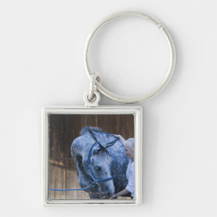 portrait of young girl holding white horse key ring