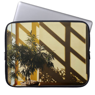 Potted green plant on brown wooden table laptop sleeve