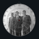 President John Kennedy & Brothers American Camelot Dartboard<br><div class="desc">The sun beat down on the three Kennedy brothers as they stood beneath the familiar white portico of the White House. President John F. Kennedy, the eldest, leaned against a pillar, a wry smile playing on his lips. His younger brothers, Robert and Ted, stood beside him, their faces a mix...</div>