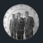 President John Kennedy & Brothers American Camelot Dartboard<br><div class="desc">The sun beat down on the three Kennedy brothers as they stood beneath the familiar white portico of the White House. President John F. Kennedy, the eldest, leaned against a pillar, a wry smile playing on his lips. His younger brothers, Robert and Ted, stood beside him, their faces a mix...</div>