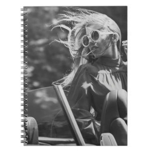 Pretty woman in convertible car notebook