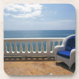 Puerto Rico. Wicker chair and tiled terrace at Coaster