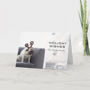 Pug dog wearing reindeer horns on couch holiday card