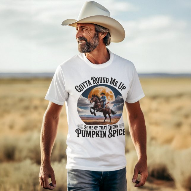 Pumpkin Spice Cowboy Coffee Lover Humour T-Shirt (ruggedly handsome cowboy wearing a funny pumpkin spice round up tee, cowboy hat, walking in pasture)