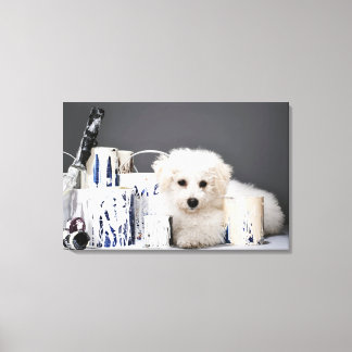Puppy sitting amongst paint tins canvas print