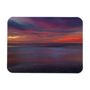 Purple-coloured sunrise on ocean shore magnet
