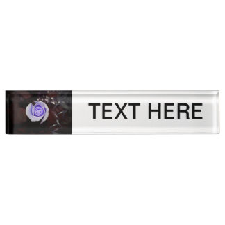 purple rose colourized flower against dark nameplate