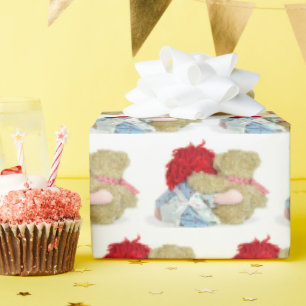 rag doll and teddy bear on white wrapping paper
