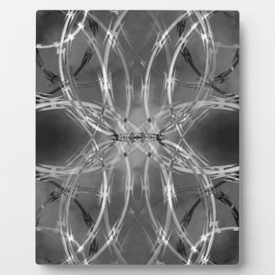 Razor wire against dark clouds plaque