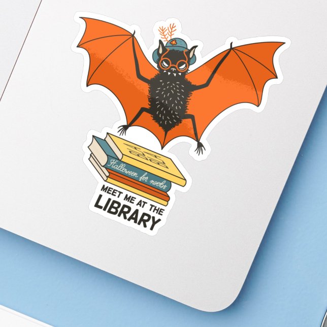 Reading Bat | Whimsical Librarian with Books (sticker of a cute cartoon bat with eyeglasses and hat flying over books on a laptop, close up)