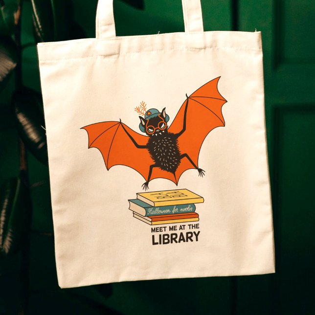 Reading Bat | Whimsical Librarian with Books Tote Bag (close up of a canvas tote bag on dark green background with a cute bat librarian cartoon)