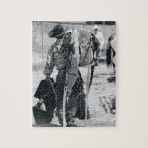 Rear view of cowboy hauling gear jigsaw puzzle