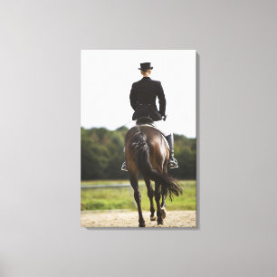 rear view of female dressage rider exercising canvas print