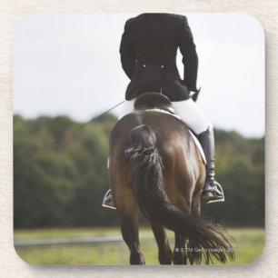 rear view of female dressage rider exercising coaster