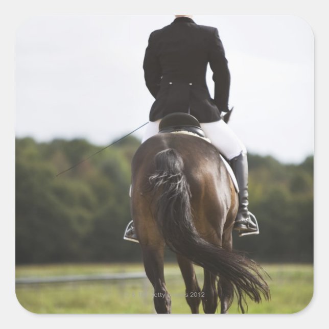 rear view of female dressage rider exercising square sticker (Front)