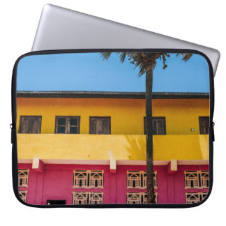 RED AND BROWN CONCRETE BUILDING NEAR TREE UNDER BL LAPTOP SLEEVE
